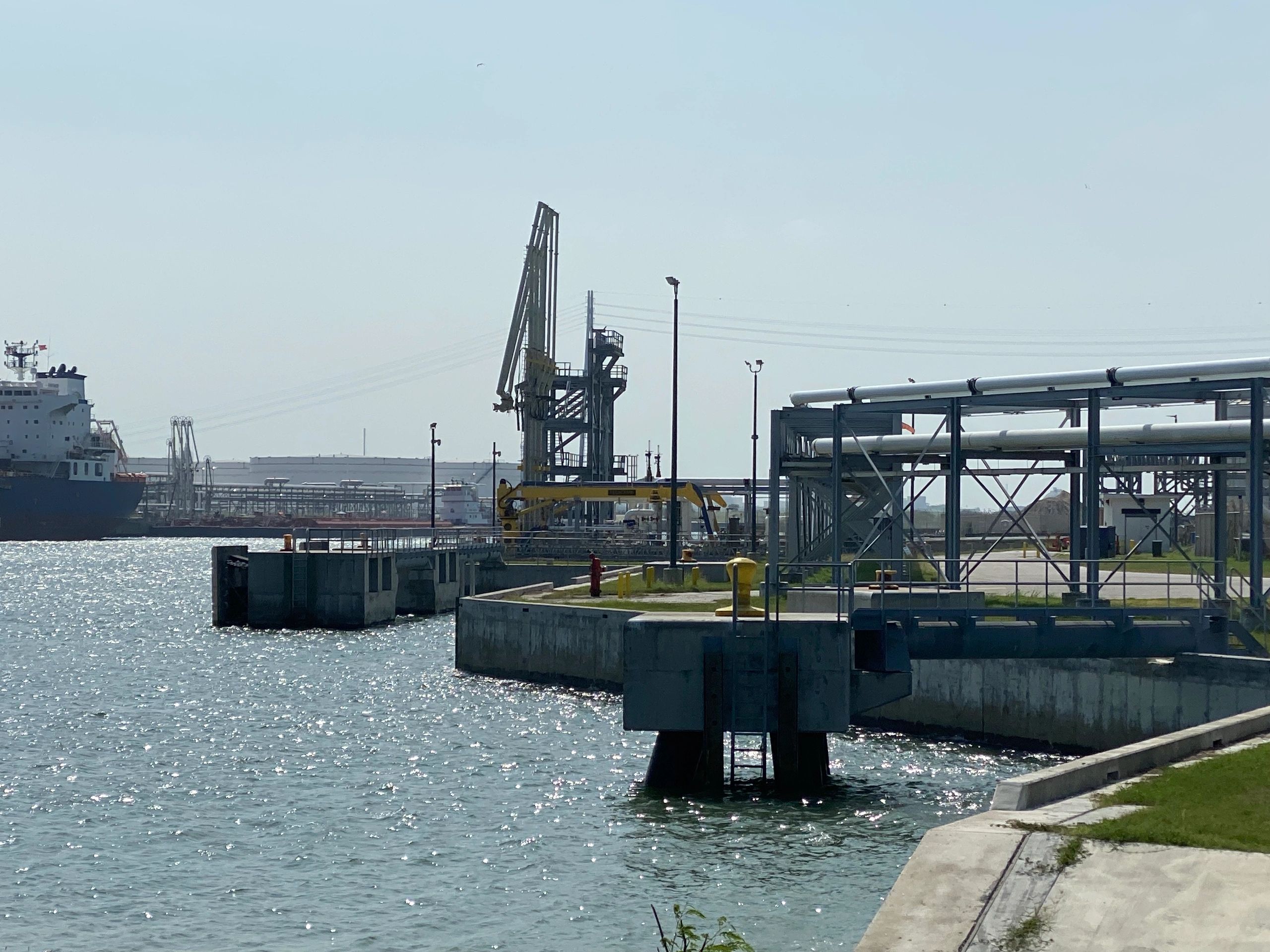 Industrial marine terminal with concrete piers, pipeline network, and a docked cargo ship
